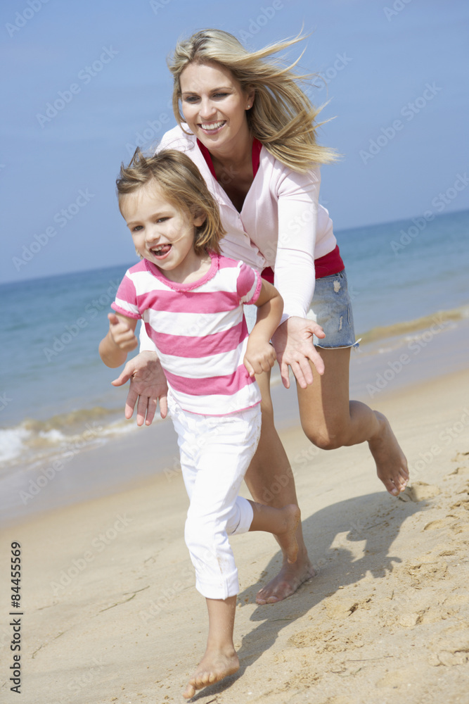 Mother Chasing Daughter Along Beach
