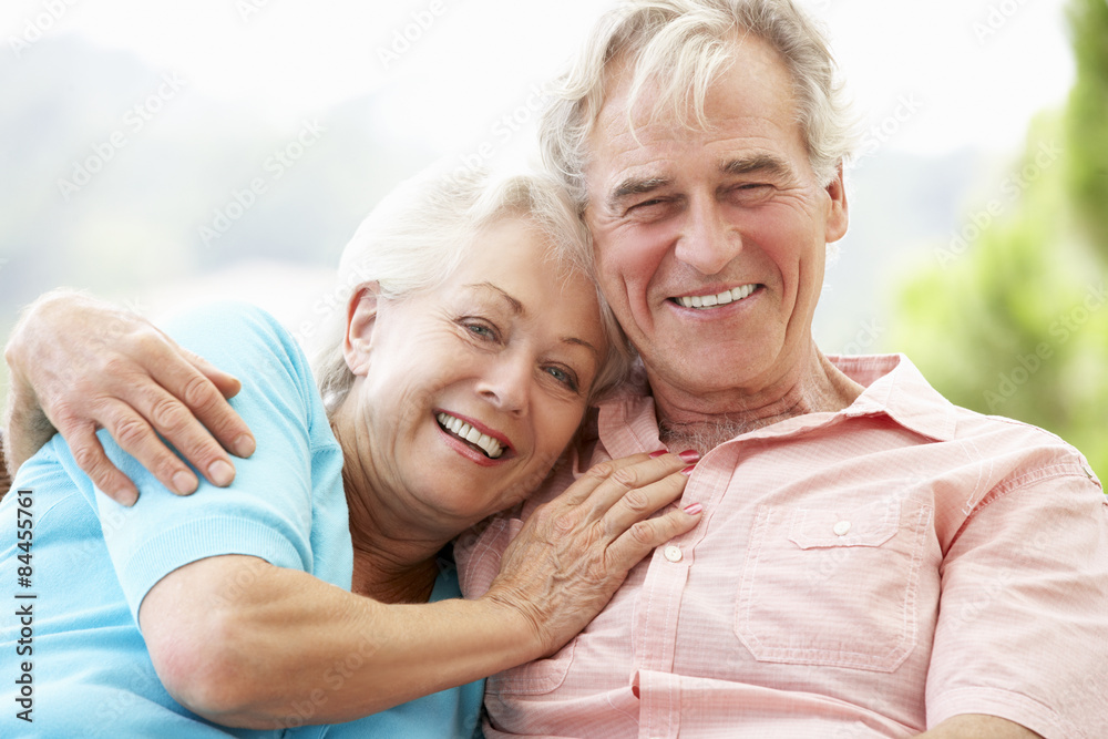 Senior Couple Sitting On Outdoor Seat Together
