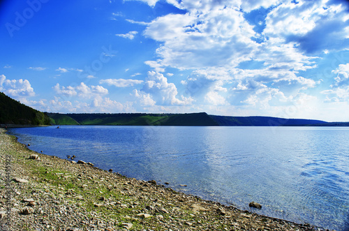 Cloudy sky and river in green landscape © dima4to