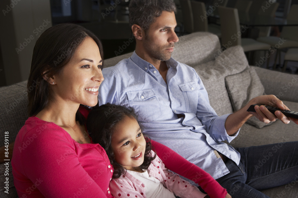 Fototapeta premium Hispanic Family Sitting On Sofa And Watching TV