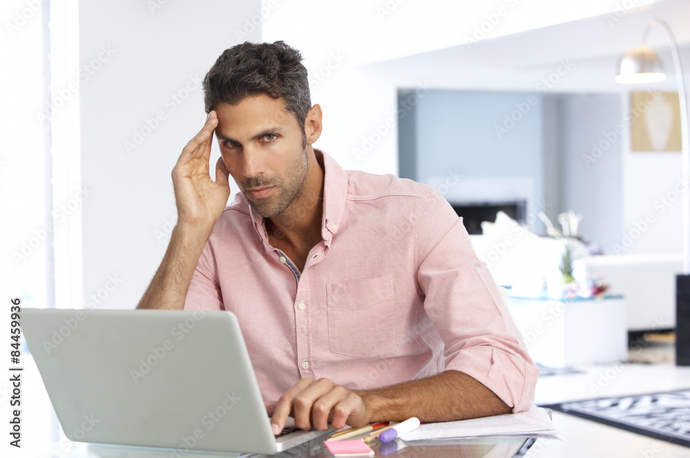 Stressed Man Working At Laptop In Home Office Stressed Man Working At Laptop In Home Office