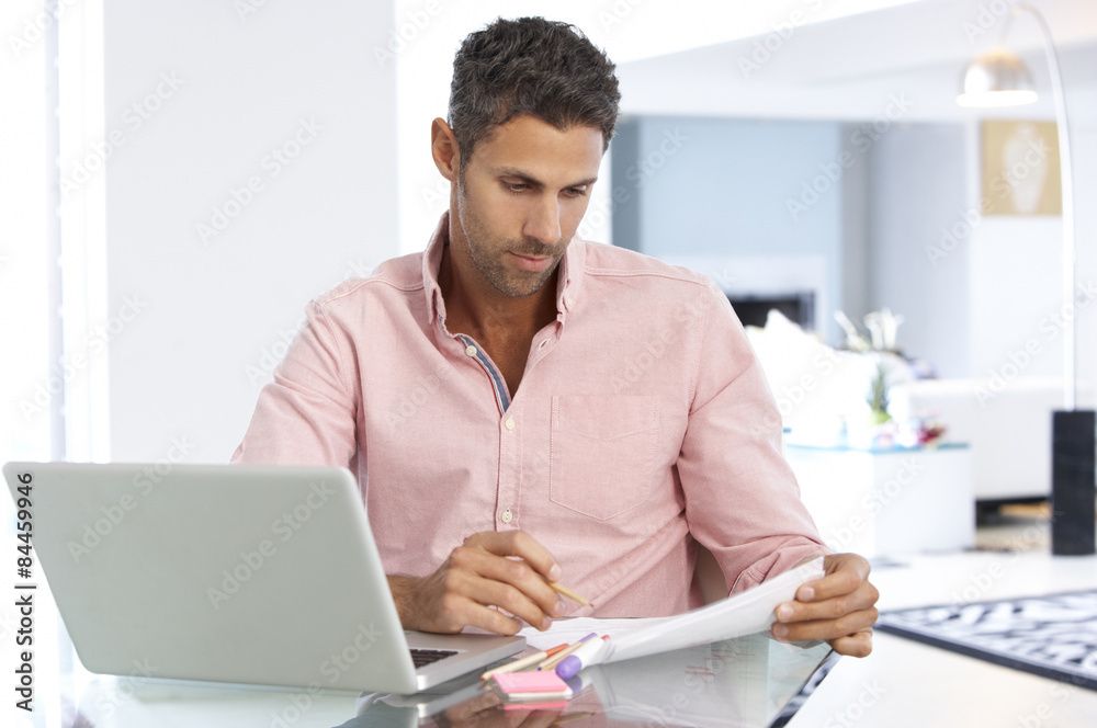 Man Working At Laptop In Home Office