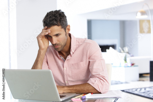 Canvas Print Stressed Man Working At Laptop In Home Office