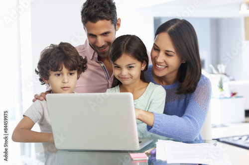 Family Working At Laptop With In Home Office