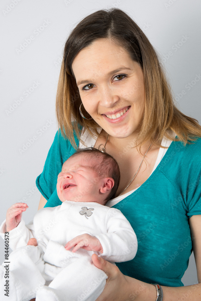 Mother holding her new born baby , smiing at the camera Mother holding her new born baby , smiing at the camera