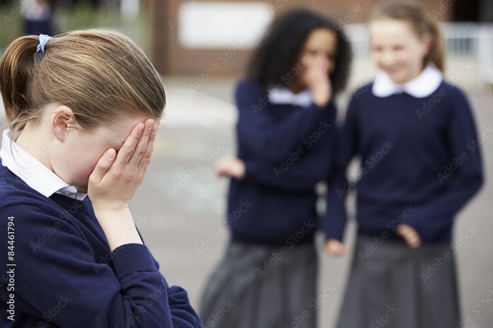 Female Elementary School Pupils Whispering In Playground Female Elementary School Pupils Whispering In Playground