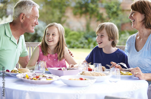 Grandparents With Grandchildren Enjoying Outdoor Meal