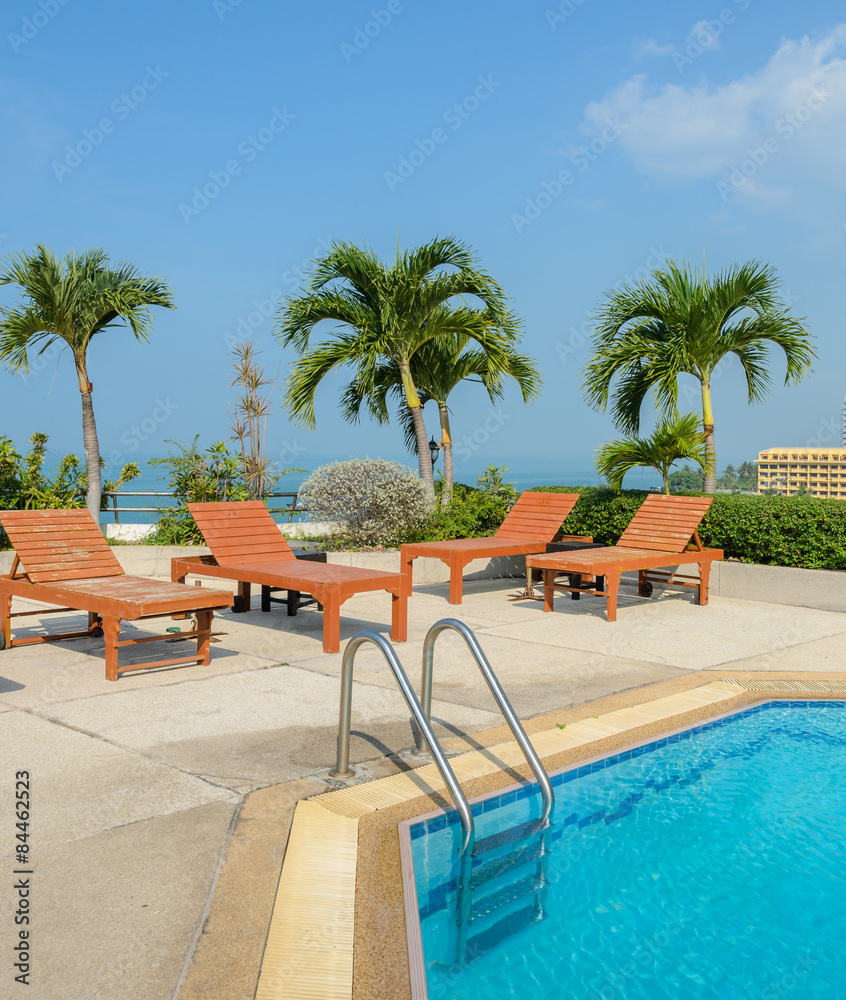 Fototapeta premium Swimming pool with wooden sun loungers