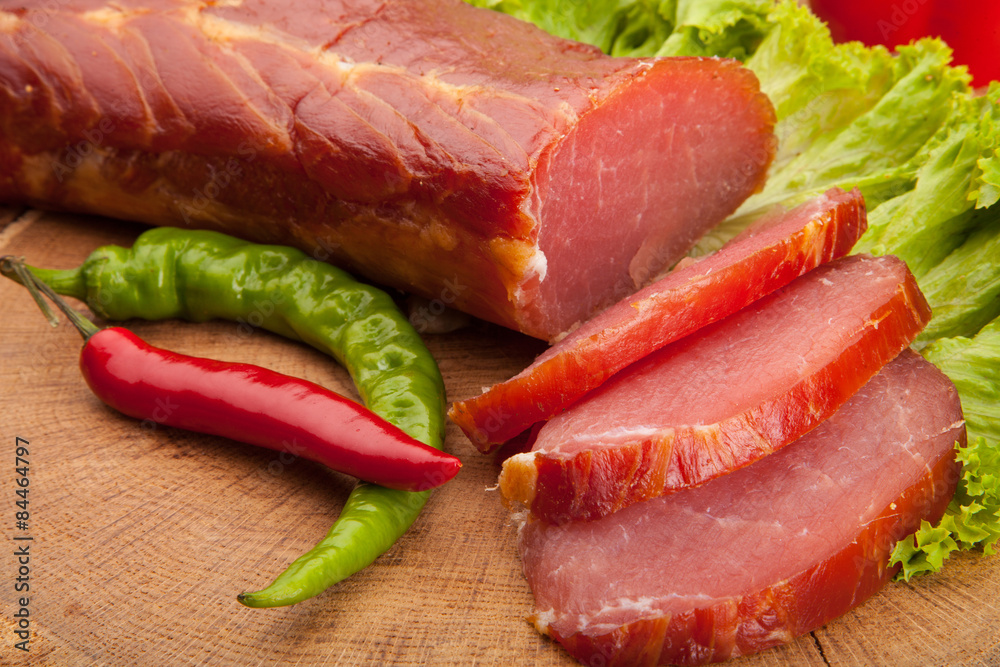 Smoked meat with bright summer vegetables on wooden background Smoked meat with bright summer vegetables on wooden background