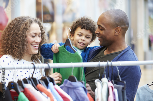 Foto Family Looking At Clothes On Rail In Shopping Mall