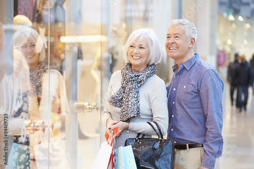 Happy Senior Couple Carrying Bags In Shopping Mall