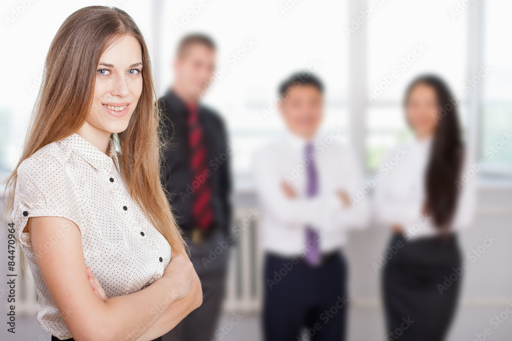 Successful business woman at foreground and business team at background Successful business woman at foreground and business team at background