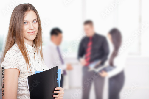 Successful business woman at foreground and business team at background © petunyia