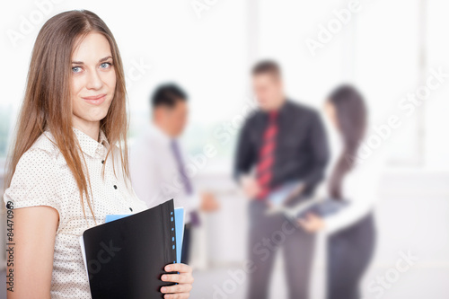 Successful business woman at foreground and business team at background