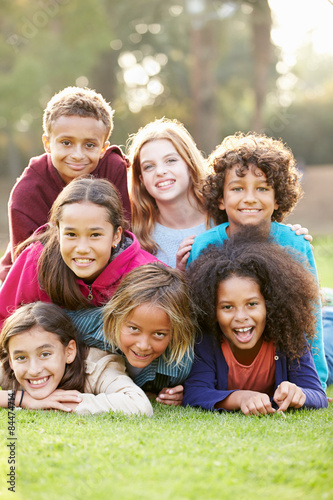 Group Of Children Lying On Grass Together In Park