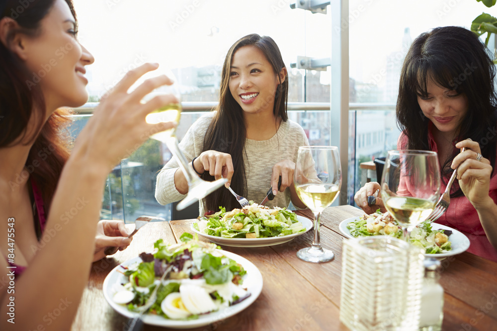 Three Female Friends Enjoying Lunch At Rooftop Restaurant Three Female Friends Enjoying Lunch At Rooftop Restaurant