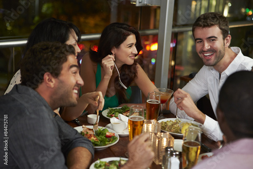 Group Of Friends Enjoying Evening Meal In Restaurant