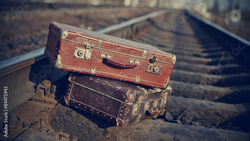 The image of vintage suitcases thrown on railway rails. photo