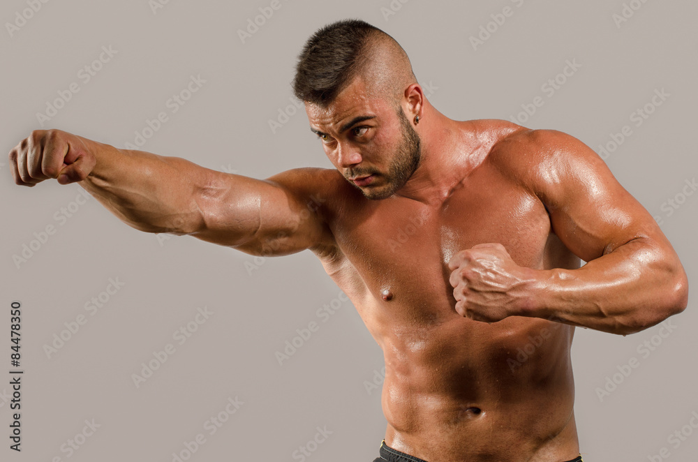 Strong bodybuilder man with perfect abs, shoulders,biceps, triceps and  chest, personal fitness trainer punching and training in boxing, mma,  kickboxing, martial arts Stock Photo | Adobe Stock