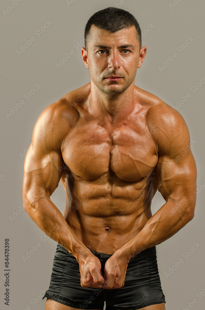 Strong bodybuilder with six pack.Strong bodybuilder man with perfect abs, shoulders,biceps, triceps and chest, personal fitness trainer flexing his muscles Strong bodybuilder with six pack.Strong bodybuilder man with perfect abs, shoulders,biceps, triceps and chest, personal fitness trainer flexing his muscles