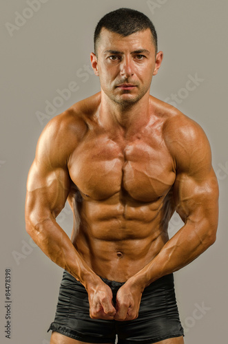 Strong bodybuilder with six pack.Strong bodybuilder man with perfect abs, shoulders,biceps, triceps and chest, personal fitness trainer flexing his muscles