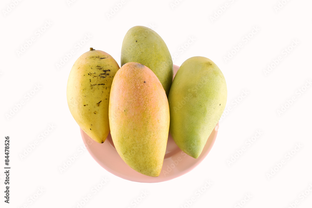 Fresh yellow mango fruit in dish isolated on white background Fresh yellow mango fruit in dish isolated on white background