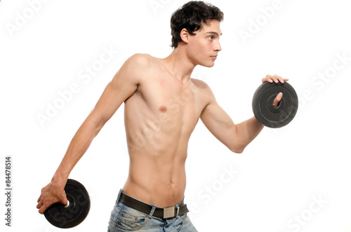 Skinny man training his bicep muscle. Beautiful teenager lifting two dumbbells.Anorexic young man training to become stronger