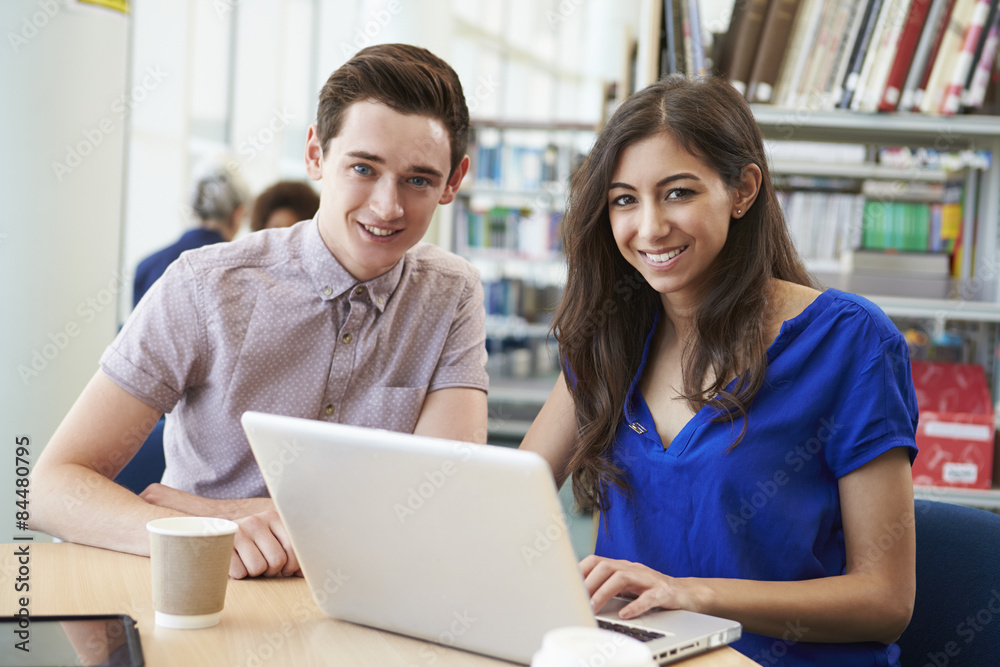 Two University Students Working In Library Using Laptop Two University Students Working In Library Using Laptop