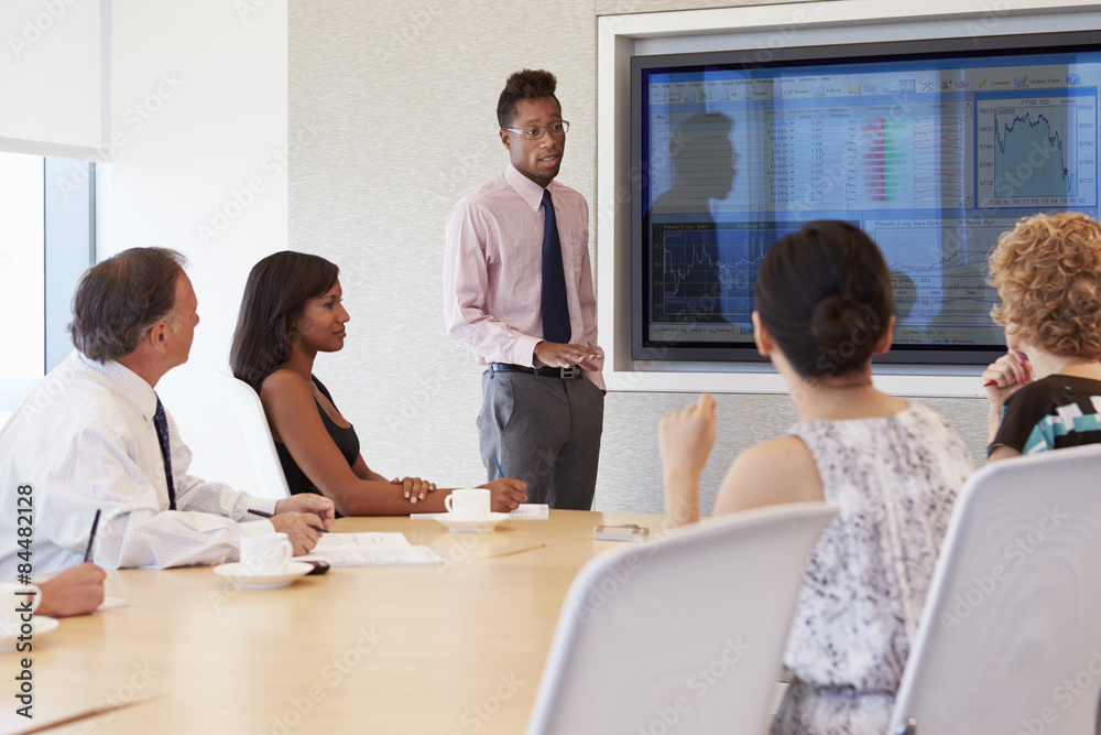 Businessman By Screen Addressing Boardroom Meeting Businessman By Screen Addressing Boardroom Meeting