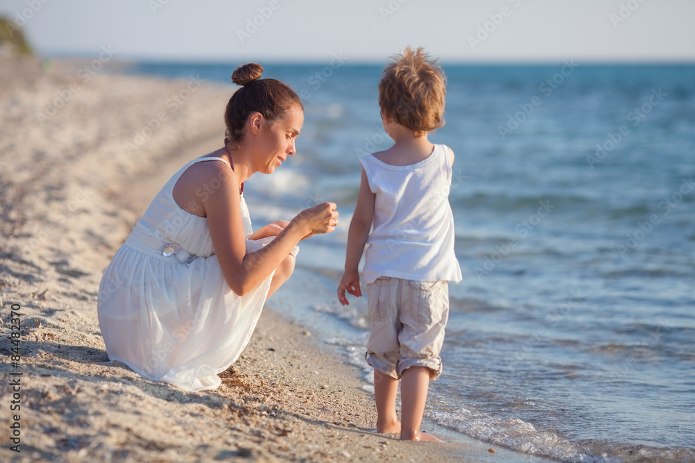 Family having fun on the beach collecting seashells Family having fun on the beach collecting seashells