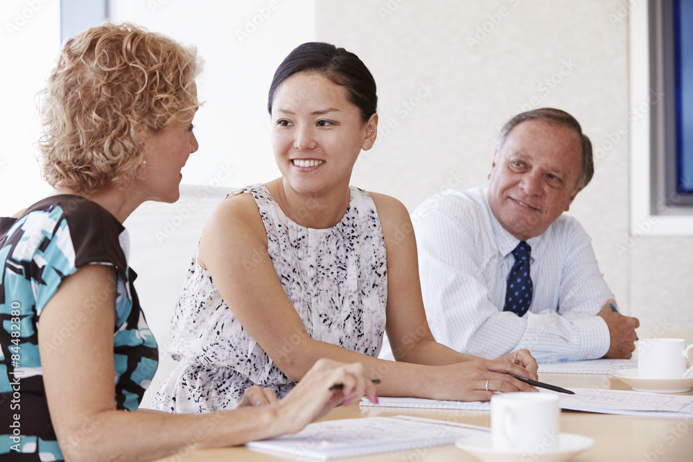 Three Businesspeople Having Meeting In Boardroom Three Businesspeople Having Meeting In Boardroom