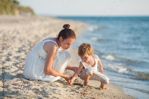 Family having fun on the beach collecting seashells