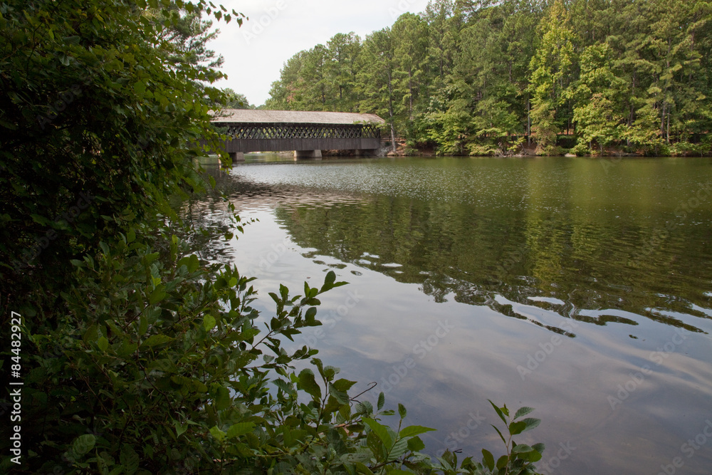 Wooden covered bridge over a still lake