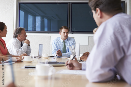 Group Of Businesspeople Meeting Around Boardroom Table