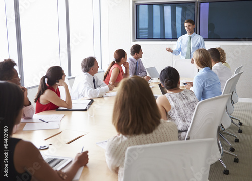 Group Of Businesspeople Meeting Around Boardroom Table