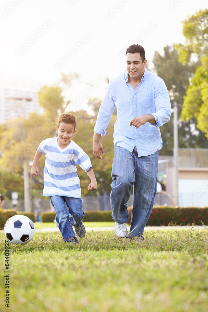 Father With Son Playing Soccer In Park Together Father With Son Playing Soccer In Park Together
