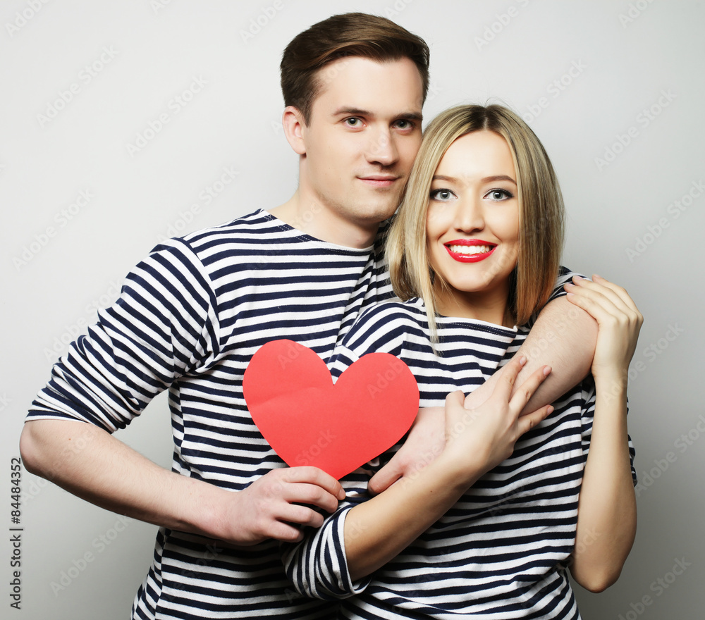 Happy couple in love holding red heart Happy couple in love holding red heart