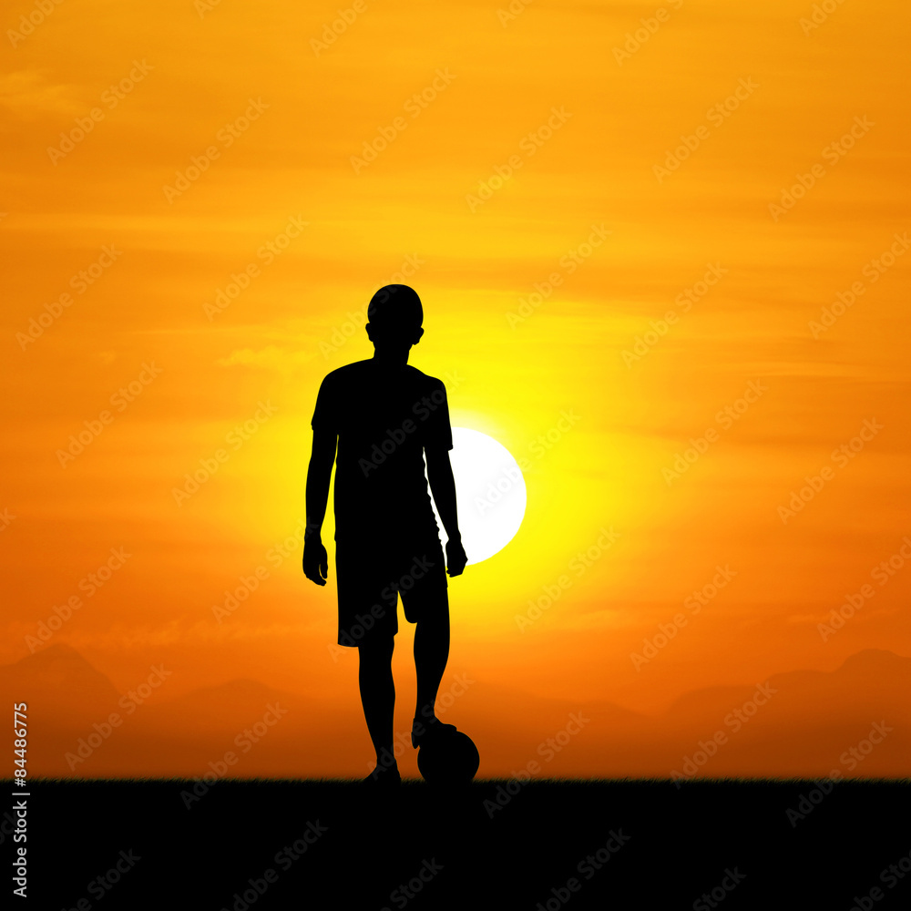 The silhouette of a soccer player during the sunset.