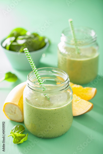 healthy green smoothie with spinach mango banana in glass jars