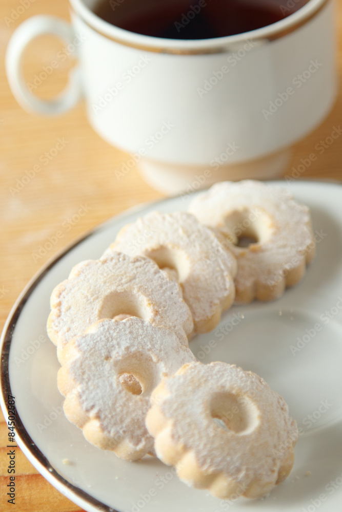 Italian Canestrelli biscuits on the saucer near a cup of black tea
