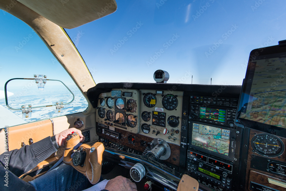 Naklejka premium cockpit of old propeller airplane with tablet for navigation