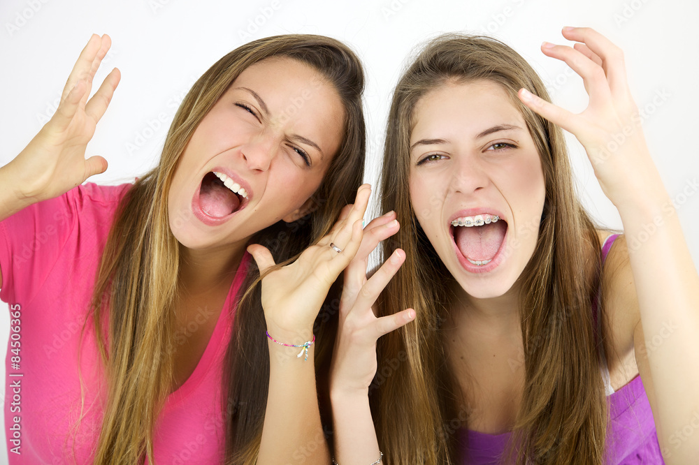 Two girls screaming like crazy looking camera isolated Two girls screaming like crazy looking camera isolated