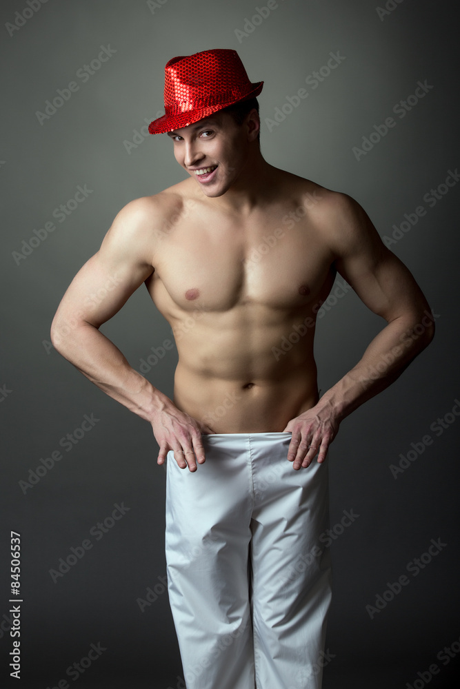 Playful dancer with muscles undressing at camera Playful dancer with muscles undressing at camera