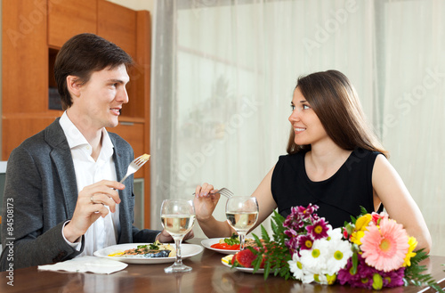 Cute man and woman having romantic dinner in home