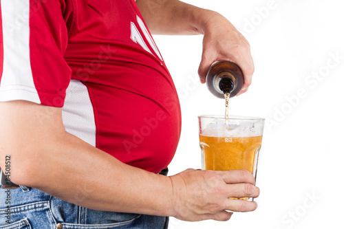 Obese man with big belly pouring a glass of refreshing beer