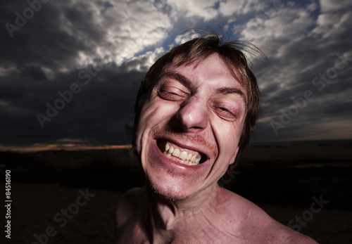 Portrait of a psycho man on a cloudy background