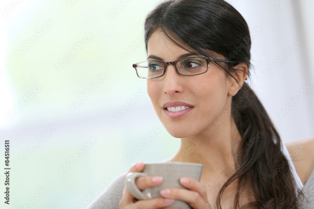 Portrait of brunette girl with eyeglasses holding cup of tea Portrait of brunette girl with eyeglasses holding cup of tea