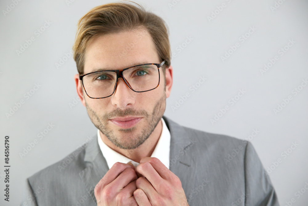Businessman with eyeglasses standing on grey background, isolated Businessman with eyeglasses standing on grey background, isolated
