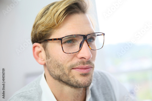 Businessman with eyeglasses sitting in front of desktop computer screen