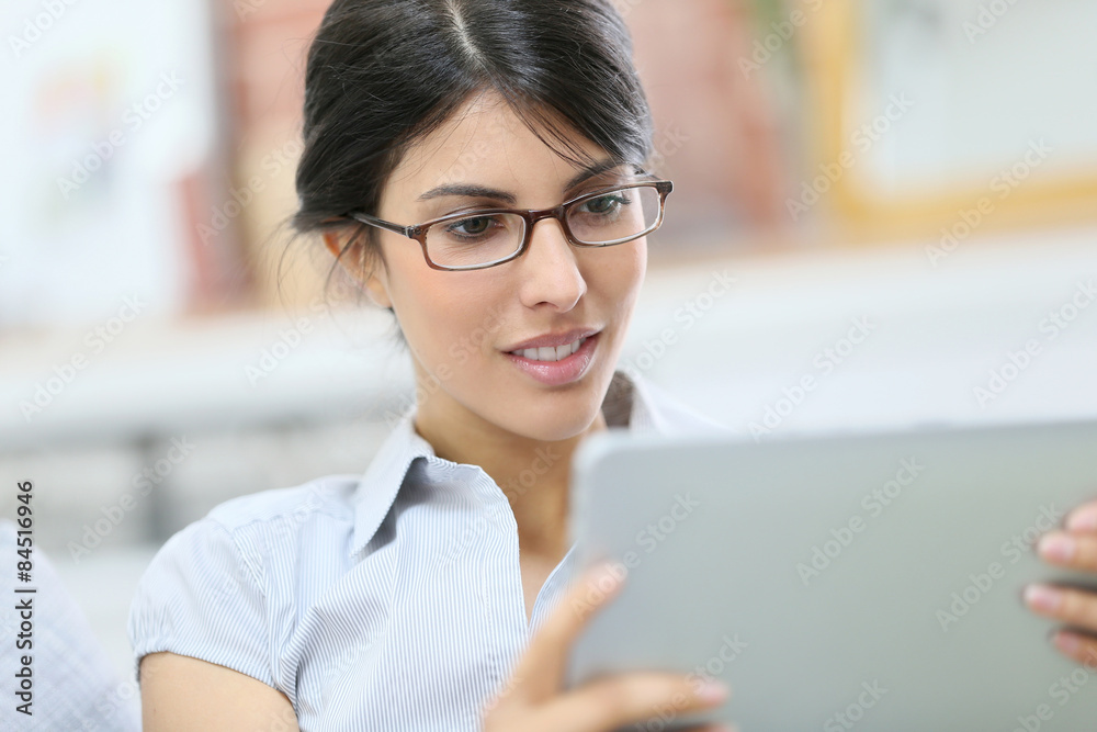 Young woman with eyeglasses using digital tablet Young woman with eyeglasses using digital tablet